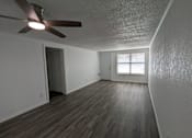 Thumbnail 12 of 25 - A room with a ceiling fan and wooden flooring.