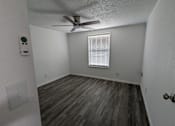 Thumbnail 23 of 25 - A room with a ceiling fan and wooden flooring.