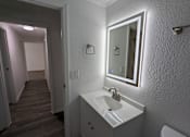 Thumbnail 17 of 25 - A bathroom with a sink, mirror, and toilet.