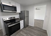 Thumbnail 20 of 25 - A kitchen with a stove, oven, microwave, and refrigerator.
