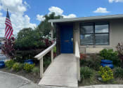 Thumbnail 10 of 21 - a home with a blue door and a porch with an flag