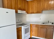Thumbnail 19 of 21 - a kitchen with white appliances and wooden cabinets