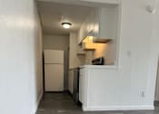 Thumbnail 8 of 21 - a long hallway with a kitchen and a refrigerator and a sink