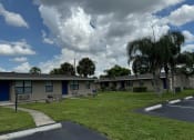 Thumbnail 6 of 21 - a row of houses with grass and palm trees