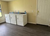 Thumbnail 17 of 21 - a room with two washers and dryers in it and a door