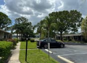 Thumbnail 16 of 21 - a car parked in a parking lot in front of a house