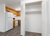 Thumbnail 11 of 24 - A white refrigerator is in a kitchen with wooden cabinets.