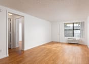 Thumbnail 8 of 24 - A room with wooden floors and white walls.