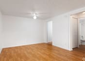 Thumbnail 10 of 24 - A room with wooden floors and white walls.