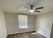 Thumbnail 10 of 43 - A room with a ceiling fan and wooden flooring.