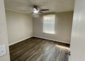 Thumbnail 11 of 43 - A room with a ceiling fan and wooden flooring.