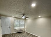 Thumbnail 9 of 43 - A room with a white door and a ceiling fan.