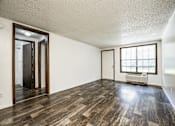 Thumbnail 41 of 43 - A room with wooden floors and a window with blinds.