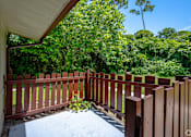 Thumbnail 40 of 43 - A wooden fence encloses a patio with a view of a green forest.
