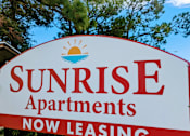 Thumbnail 12 of 32 - a sign that reads sunrise apartments now leasing