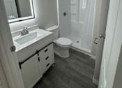 Thumbnail 11 of 32 - A white bathroom with a toilet, sink, and shower.