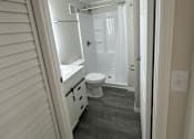 Thumbnail 10 of 32 - A bathroom with a toilet, sink, and shower.