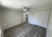 Thumbnail 8 of 32 - A room with a ceiling fan and a door.