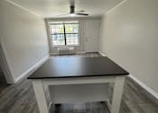 Thumbnail 6 of 32 - A room with a table and a window.