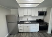 Thumbnail 4 of 32 - A kitchen with a refrigerator, sink, and oven.