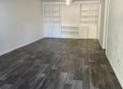 Thumbnail 13 of 16 - an empty living room with wood flooring and a closet