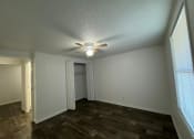 Thumbnail 30 of 33 - a living room with a ceiling fan and a door to a closet