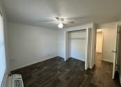 Thumbnail 31 of 33 - an empty living room with a ceiling fan and a closet