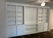Thumbnail 25 of 33 - a room with white shelves and a ceiling fan