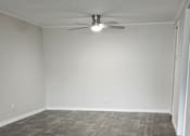 Thumbnail 5 of 33 - A room with a ceiling fan and wooden flooring.