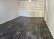 Thumbnail 21 of 22 - an empty living room with wood flooring and a closet