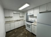 Thumbnail 20 of 22 - an empty kitchen with white cabinets and white appliances