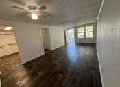 Thumbnail 18 of 22 - an empty living room and kitchen with a ceiling fan