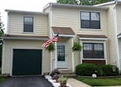 Thumbnail 2 of 21 - a yellow house with an flag in front of it