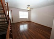 Thumbnail 19 of 21 - an empty living room with a ceiling fan and a stairs