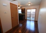 Thumbnail 16 of 21 - an empty living room with a door to a kitchen