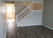 Thumbnail 2 of 18 - an empty living room with wood floors and a staircase