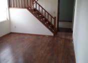 Thumbnail 8 of 18 - an empty living room with wood floors and a staircase