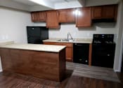 Thumbnail 7 of 11 - a kitchen with wooden cabinets and black appliances