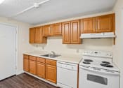 Thumbnail 40 of 44 - A kitchen with white appliances and wooden cabinets.