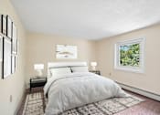 Thumbnail 27 of 44 - A bedroom with a large bed and a window showing greenery outside.