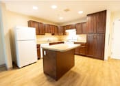 Thumbnail 3 of 16 - A kitchen with wooden cabinets and a white refrigerator.