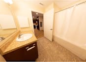 Thumbnail 8 of 16 - A bathroom with a sink, mirror, and shower.