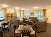 Thumbnail 12 of 16 - A well-lit living room with a dining table and chairs.