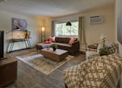 Thumbnail 8 of 19 - A living room with a brown couch and a patterned chair.