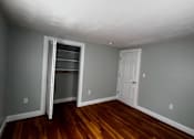 Thumbnail 2 of 7 - A room with a wooden floor and a white door.