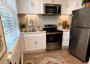 Thumbnail 24 of 26 - A kitchen with a refrigerator, oven, and sink.