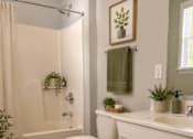Thumbnail 25 of 26 - A bathroom with a toilet, sink, and shower.