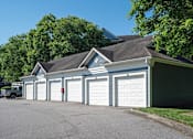 Thumbnail 32 of 35 - A row of white garage doors in front of a house.