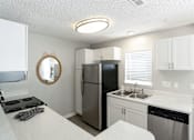 Thumbnail 5 of 35 - A kitchen with a black fridge and stove top oven.