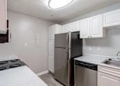 Thumbnail 20 of 35 - A kitchen with a refrigerator, stove, and sink.